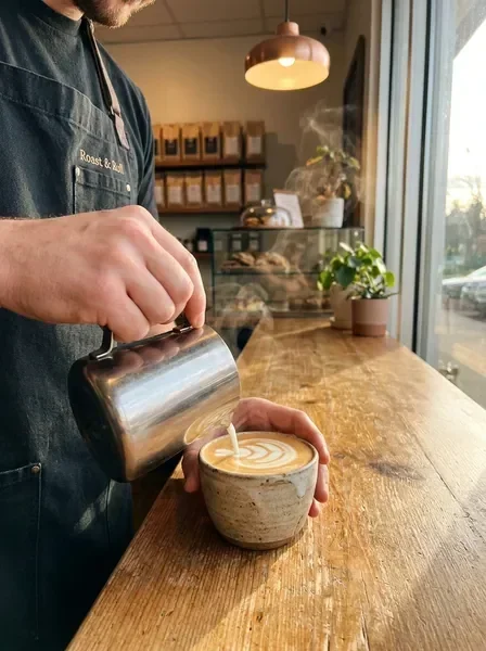 Barista creating latte art at Roast & Roll coffee shop